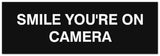Signs ByLITA Basic Smile you're on camera Sign - Laser-Engraved Lettering | Durable ABS Plastic | Vibrant Colors | Powerful Foam Tape