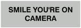 Signs ByLITA Basic Smile you're on camera Sign - Laser-Engraved Lettering | Durable ABS Plastic | Vibrant Colors | Powerful Foam Tape