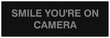 Signs ByLITA Basic Smile you're on camera Sign - Laser-Engraved Lettering | Durable ABS Plastic | Vibrant Colors | Powerful Foam Tape