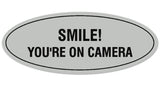 Signs ByLITA Oval Smile You're on Camera Sign - Laser-Engraved Lettering | Durable ABS Plastic | Vibrant Colors | Powerful Foam Tape
