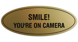 Signs ByLITA Oval Smile You're on Camera Sign - Laser-Engraved Lettering | Durable ABS Plastic | Vibrant Colors | Powerful Foam Tape